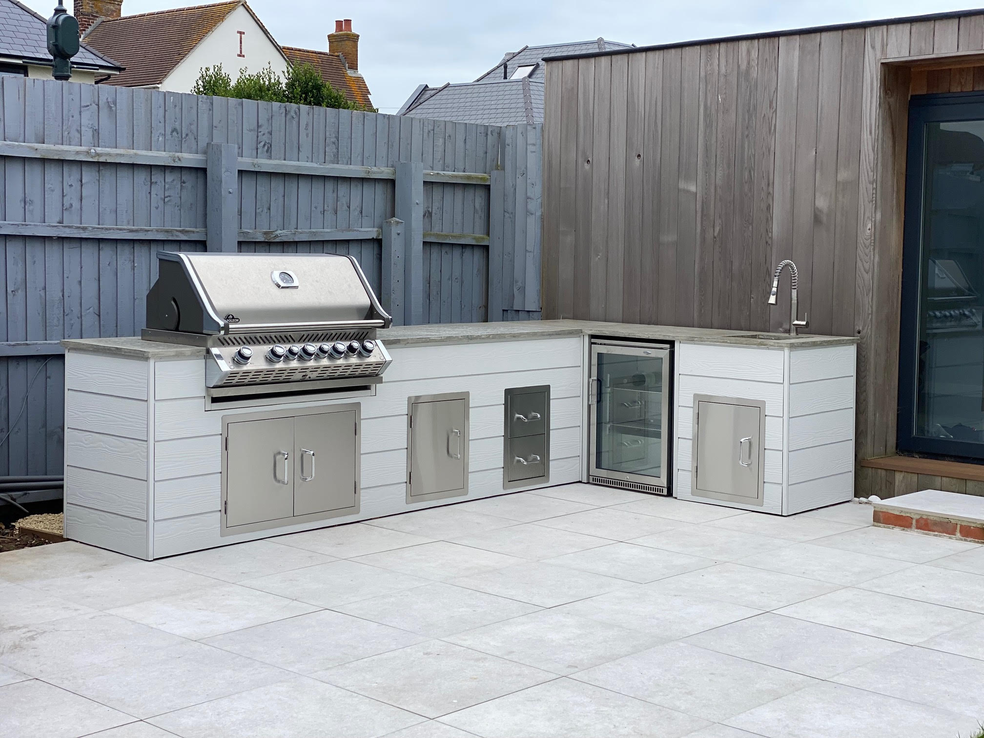 metal framed outdoor kitchen with cladded exterior, topped with polished concrete worktops